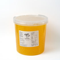 Close-up of Mango Popping Boba, vibrant yellow pearls, ready-to-use ingredient for fast-serve foodservice.