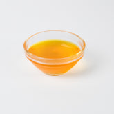 Thick, vibrant yellow Mango syrup being poured, highlighting its smooth consistency and rich colour.