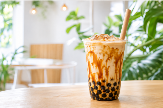 Less-sweet brown sugar oat milk boba in a clear plastic takeaway cup