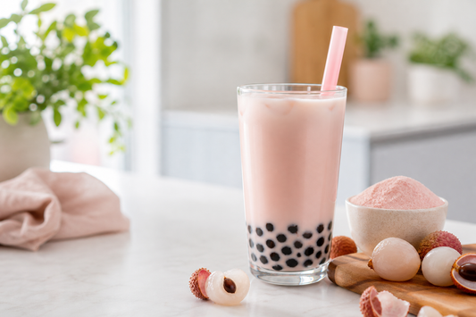 Blush pink homemade lychee bubble milk tea with fresh lychees in a bright UK kitchen