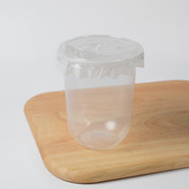 Clear disposable bubble tea cups (95mm) shown with matching flat lids and sealing film for wholesale.