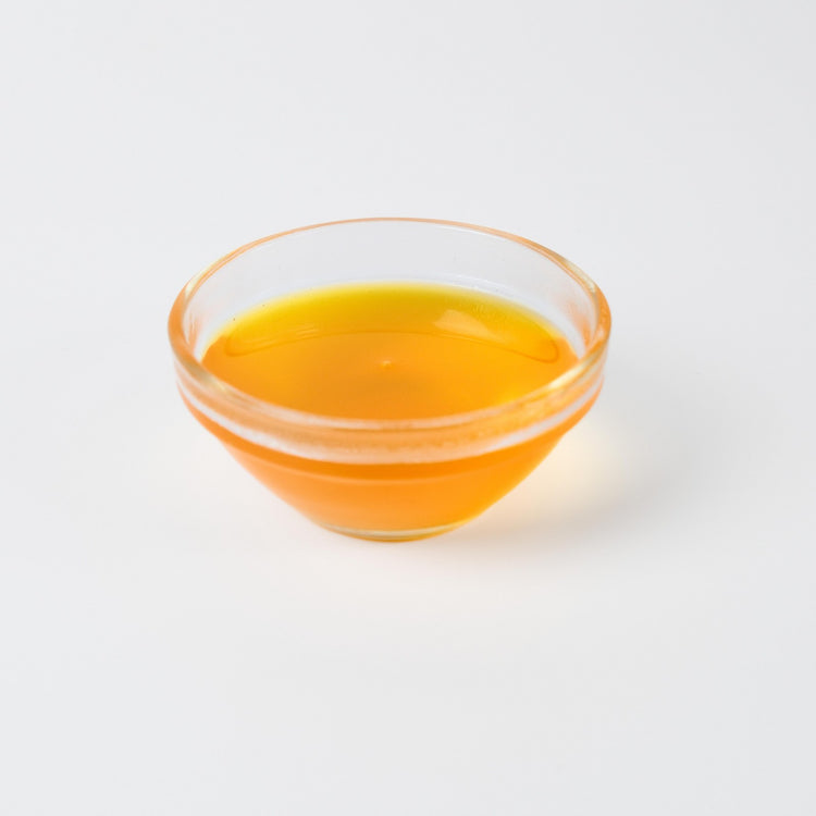 Thick, vibrant yellow Mango syrup being poured, highlighting its smooth consistency and rich colour.