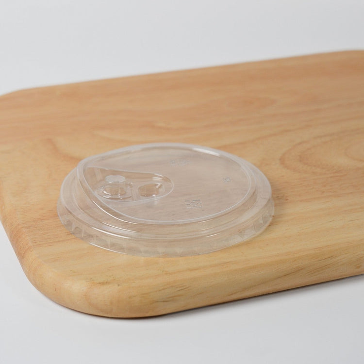 Wholesale clear plastic flat sip lid for 90mm bubble tea cups, featuring a direct drinking hole and a removable plug for leak prevention.