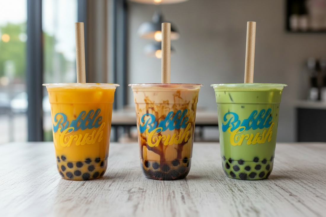 Three bubble tea drinks with different flavors on a wooden table.