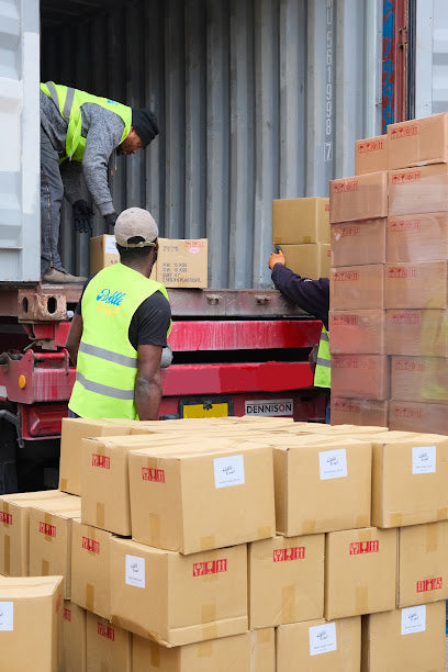 Workers handling stacked cardboard boxes with 'Bubble Crush' branding in a warehouse setting.